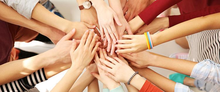 teens putting hands together in a huddle